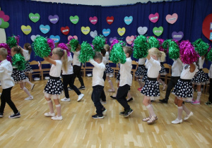 przedszkolaki tańczą z kolorowymi pomponami